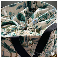 Vue de haut du Magnifique cabas Botanic glam fermé de Tatamo ayant comme motif des feuillages, fleurs et un paon majestueux. Collection Rifle Paper